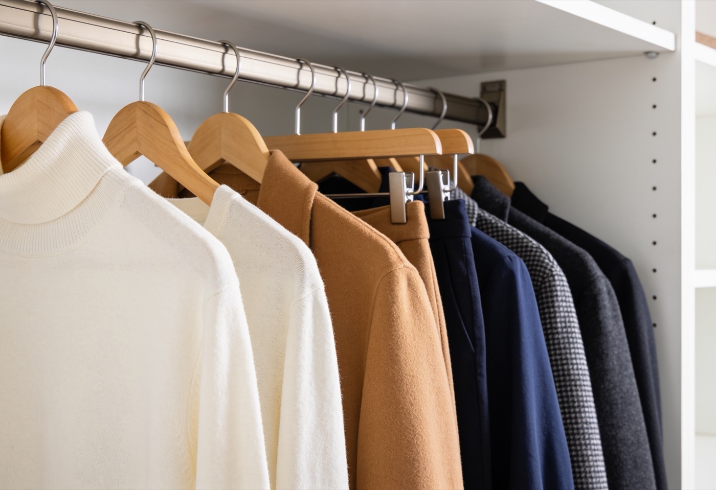 A disciplined palette on a single rail — cream, camel, navy, charcoal.